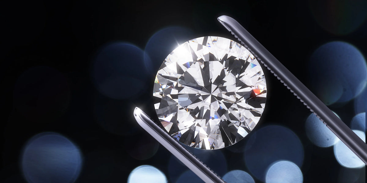 Close-up of a brilliant-cut diamond held in tweezers