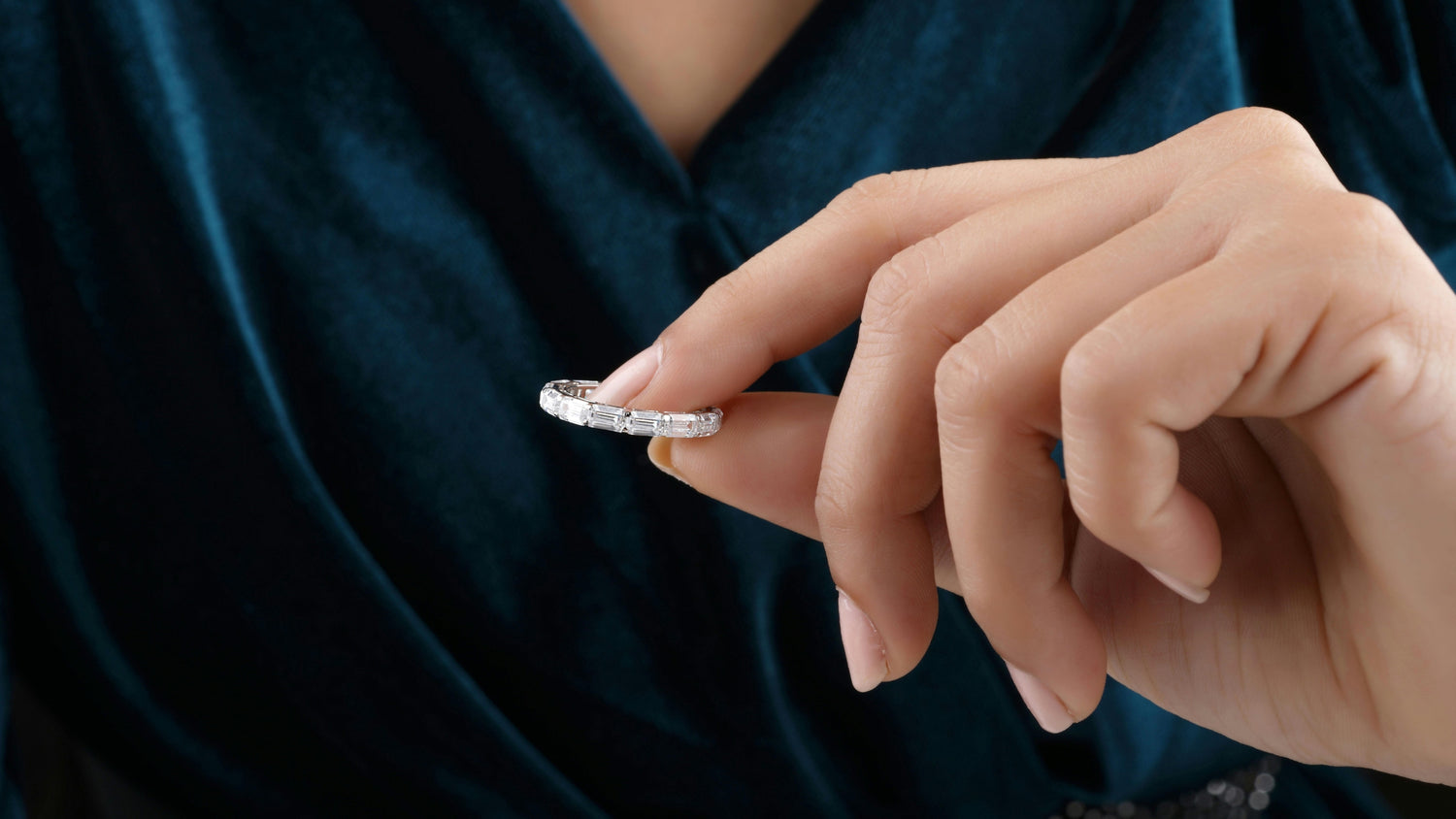 Close-up of a woman holding a clean, sparkling ring, showcasing its brilliance and elegance.